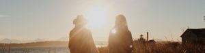 Two people at a farm on a sunny day.